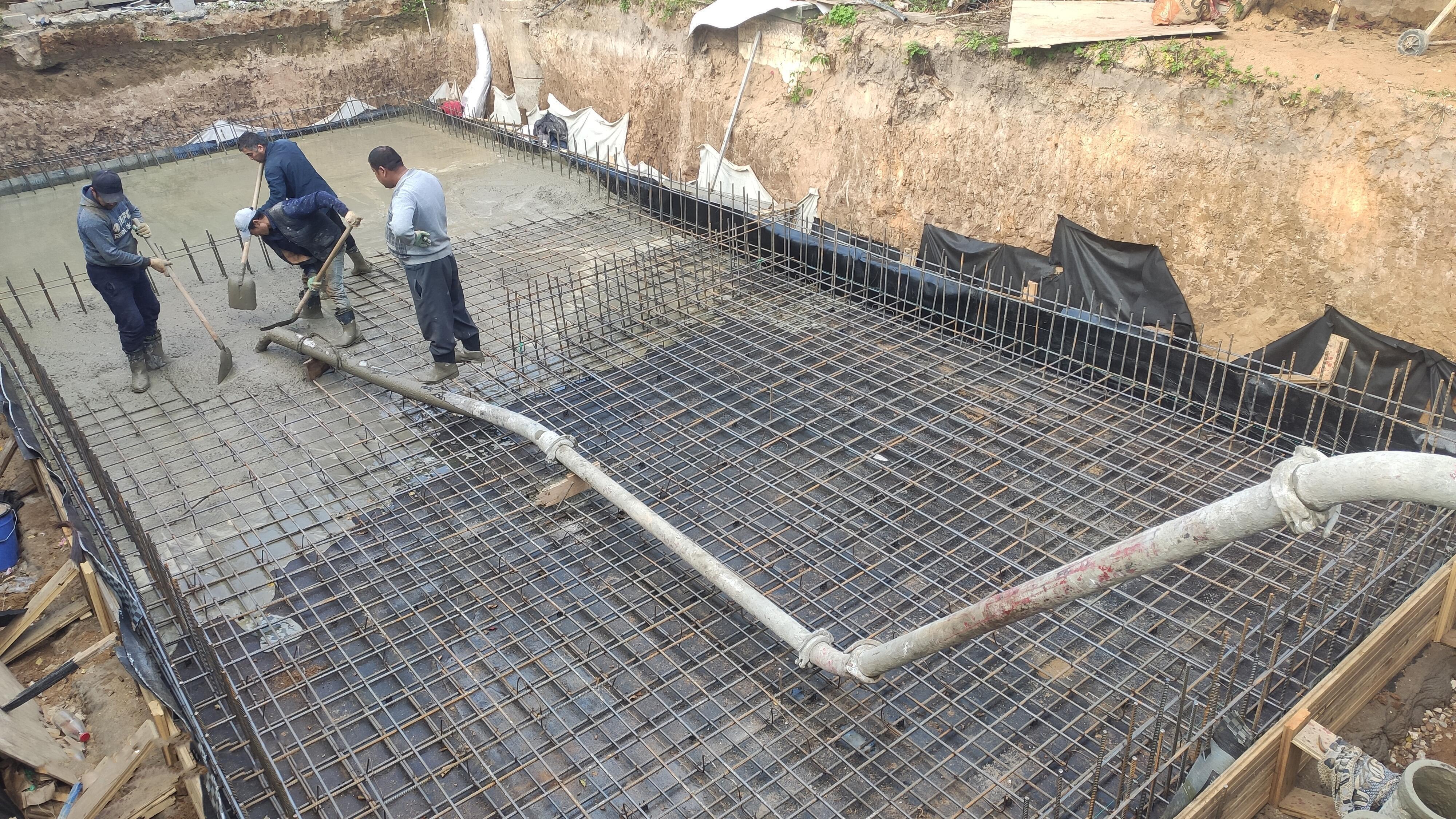Бетононасос подает жидкий бетон на граните тяжёлого класса B30 – заливка плиты фундамента