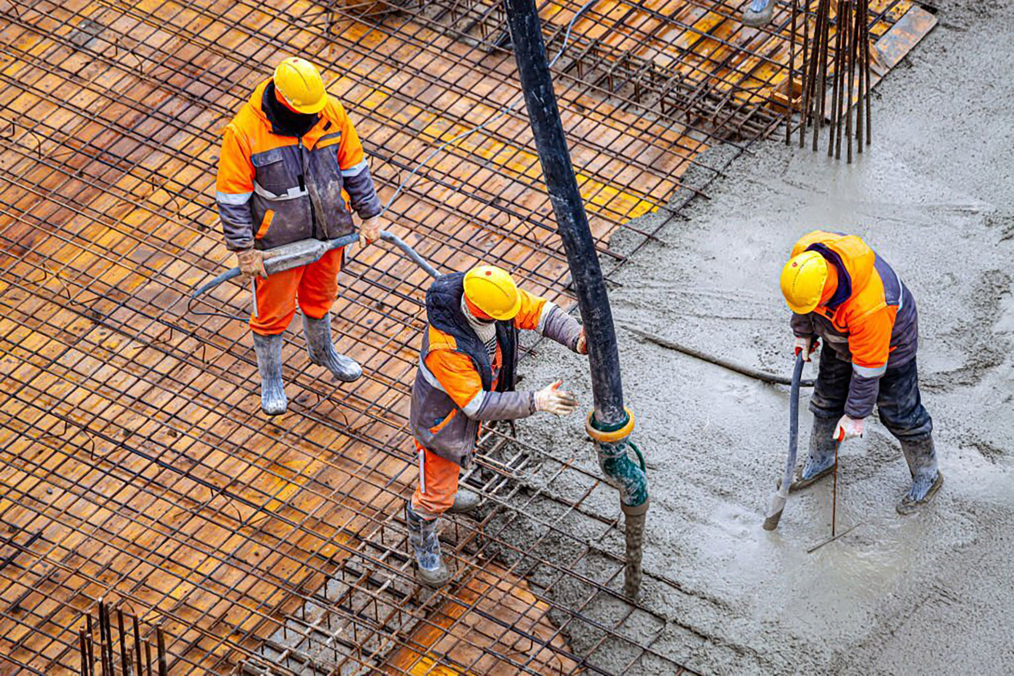 Бригада бетонщиков заливает фибробетон для фундаментной плиты